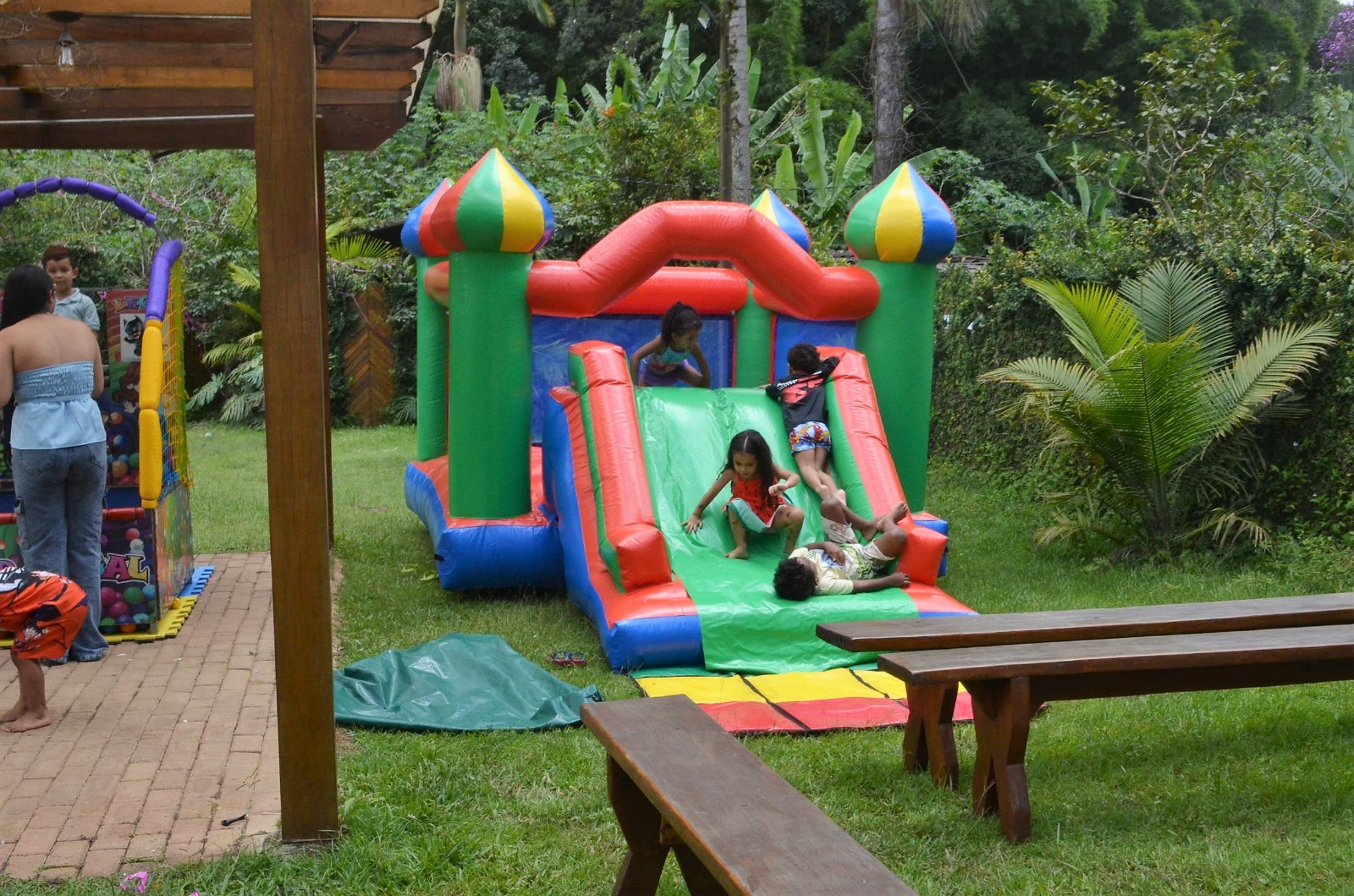 Pula-pula infantil em formato de castelo colorido montado no gramado
